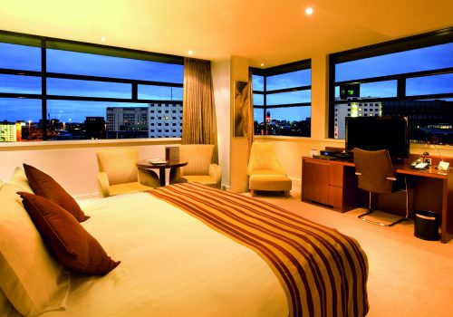 Bedroom with a panoramic view at dusk at Macdonald Manchester Hotel & Spa NCN